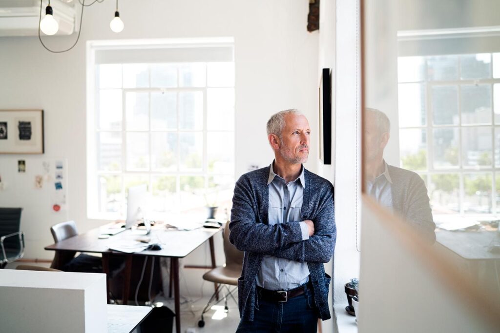 man looking out window